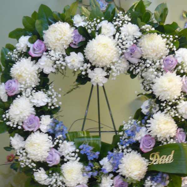 Heart-shaped floral wreath with white mums, lavender roses, and blue accents