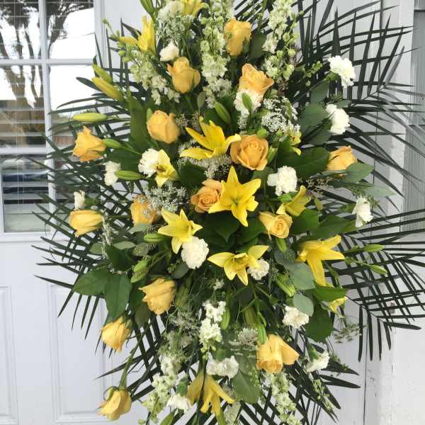 Large standing spray of yellow roses and lilies with white accents