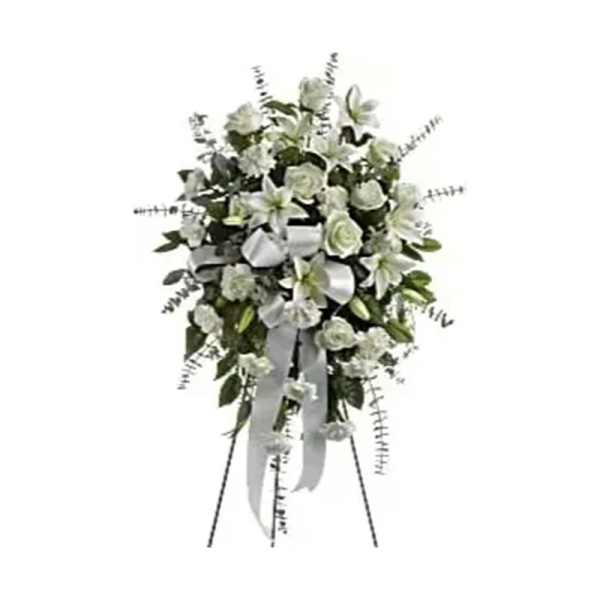 White floral standing spray with lilies and roses on an easel