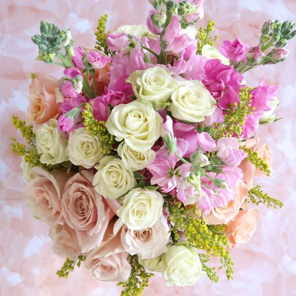 Bouquet of pink and cream roses with small pink blooms