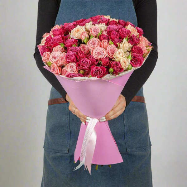 Large bouquet of pink and cream roses wrapped in pink paper