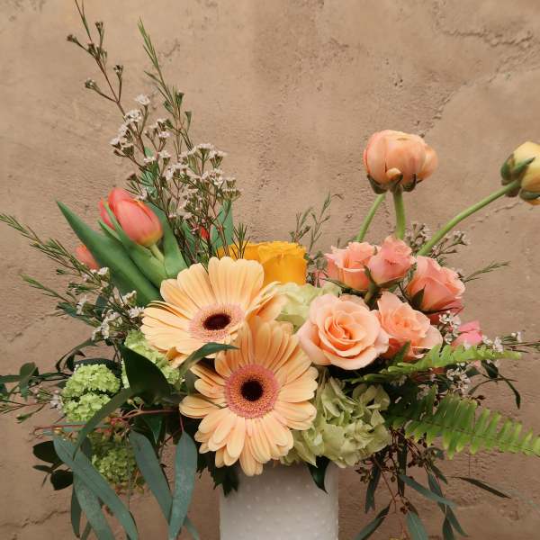 Peach and pink mixed bouquet in a white textured vase