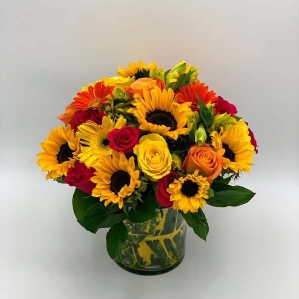 Bouquet of sunflowers and roses in a glass vase