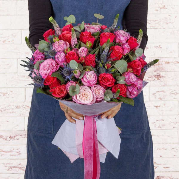 Handheld bouquet of pink and red roses with eucalyptus and ribbon wrap
