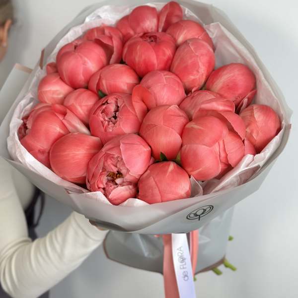 Bouquet of pink peonies wrapped in pale paper