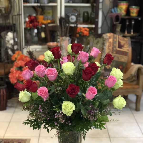 Bouquet of pink, red, and lime roses in a clear glass vase