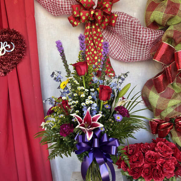 Mixed bouquet with red roses and lilies in a glass vase