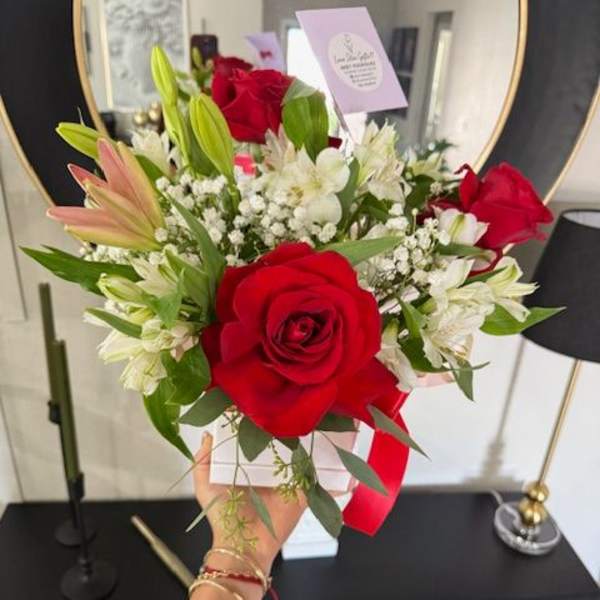Bouquet of red roses and white lilies with baby's breath in a white box
