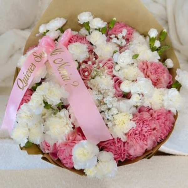 Pink and white flower bouquet wrapped in brown paper with a pink ribbon