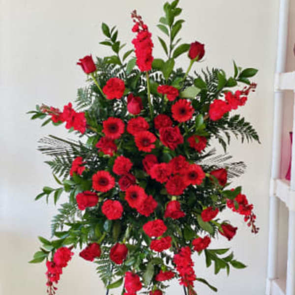 Tall standing spray of red flowers on a metal easel