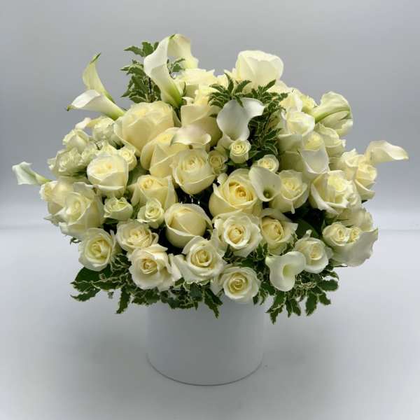 White roses and calla lilies in a white hatbox