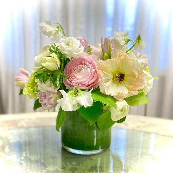 Pastel bouquet in a green glass vase with pink and white blooms