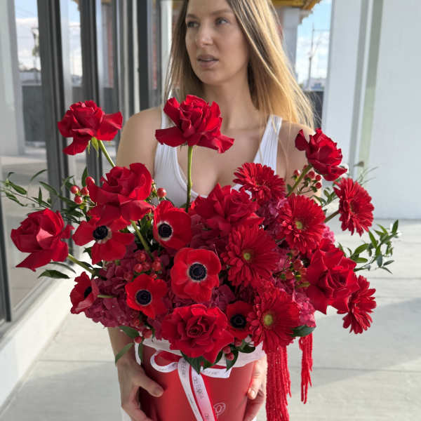 Woman holding a large red bouquet in a round box