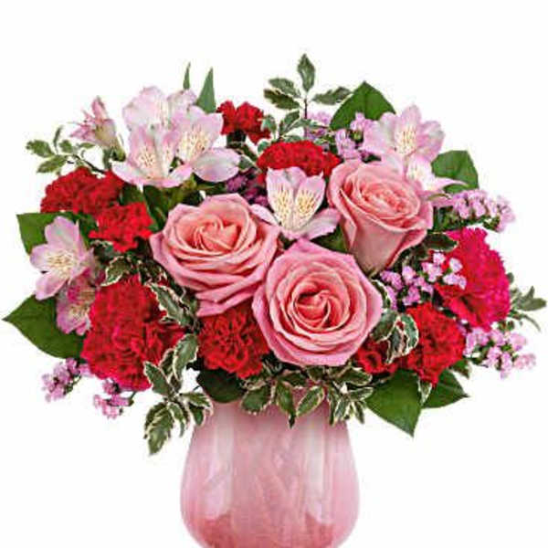 Pink roses and red carnations in a pink glass vase