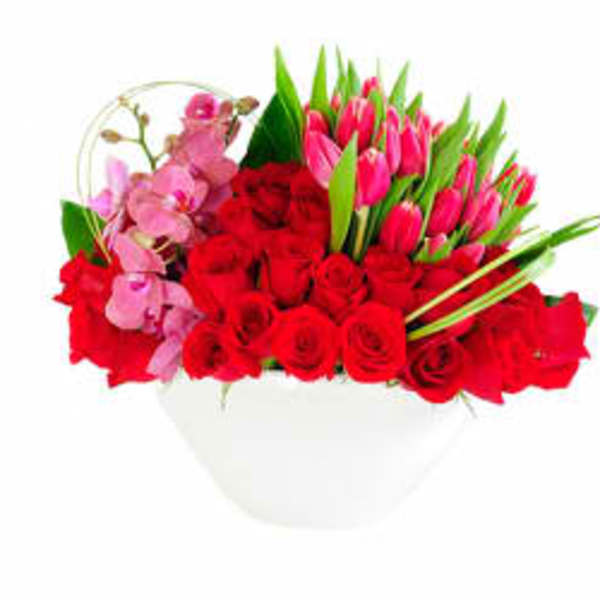 Bouquet of red roses and pink tulips in a white vase