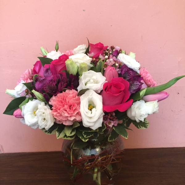Mixed pink, white, and purple bouquet in a glass vase