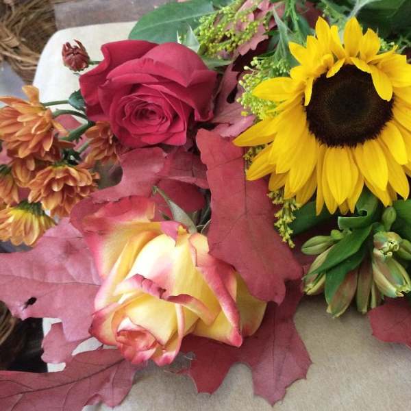 Bouquet with sunflowers, roses, and autumn leaves