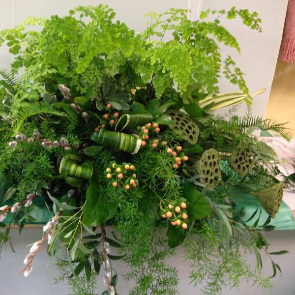 Large green floral arrangement with ferns and berry accents