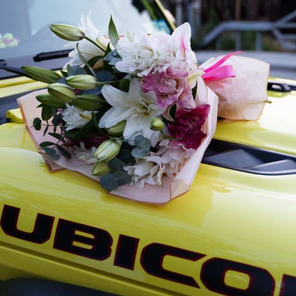 Bouquet of white and pink lilies wrapped in pale paper