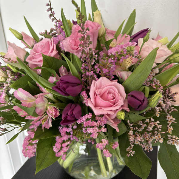 Pink and purple mixed bouquet in a clear glass vase