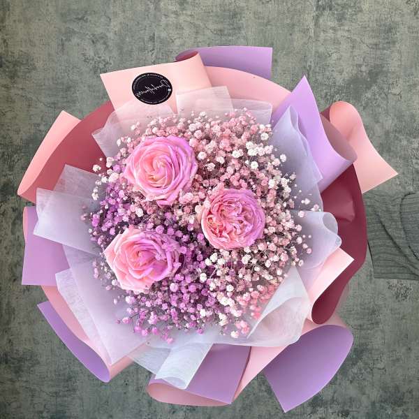 Pink roses with baby's breath wrapped in pastel paper