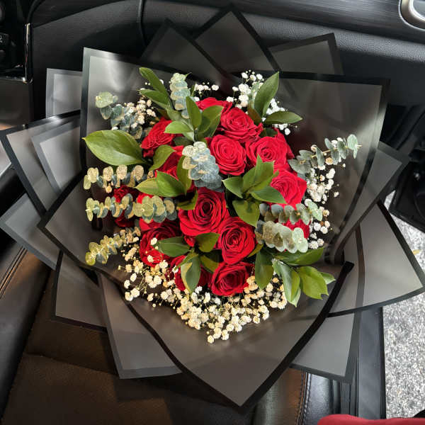 Bouquet of red roses with eucalyptus and baby's breath in black wrap