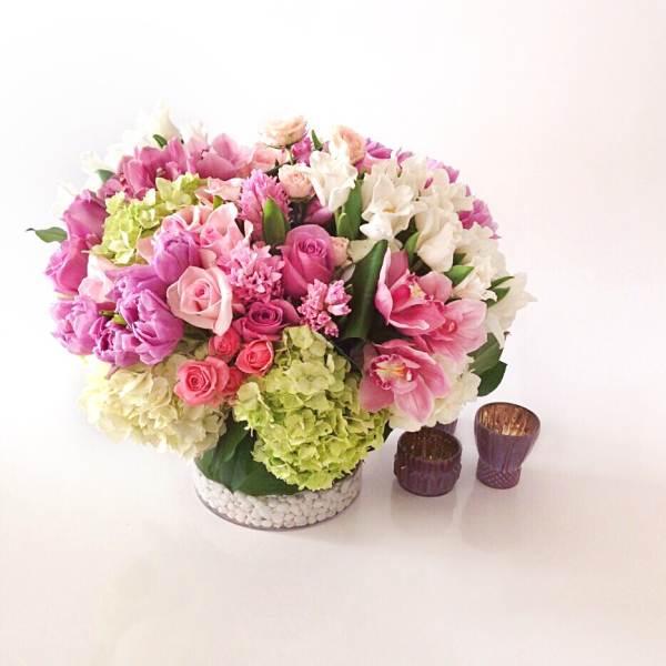 Mixed pink and white flower arrangement in a low glass vase