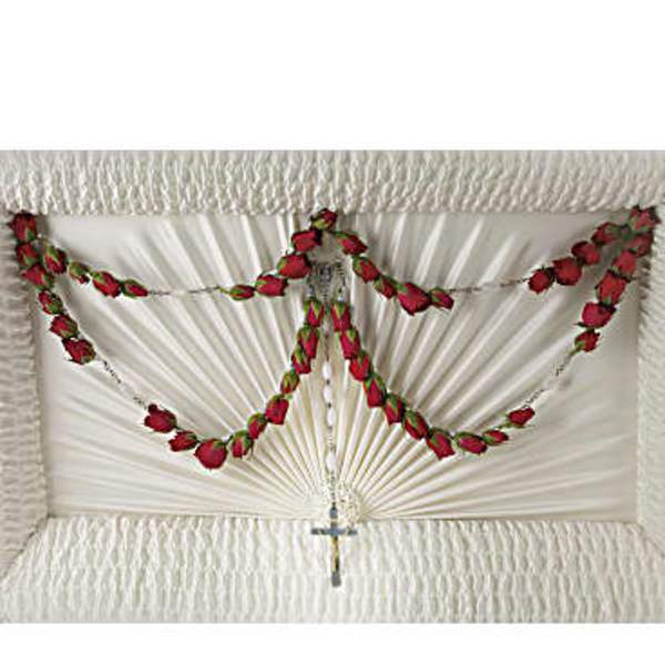 White funeral casket with red rose garlands and a small cross
