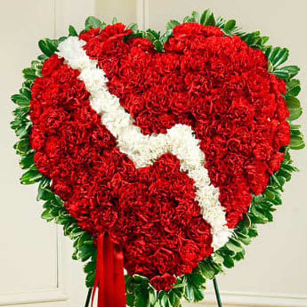 Heart-shaped red and white floral standing spray on an easel