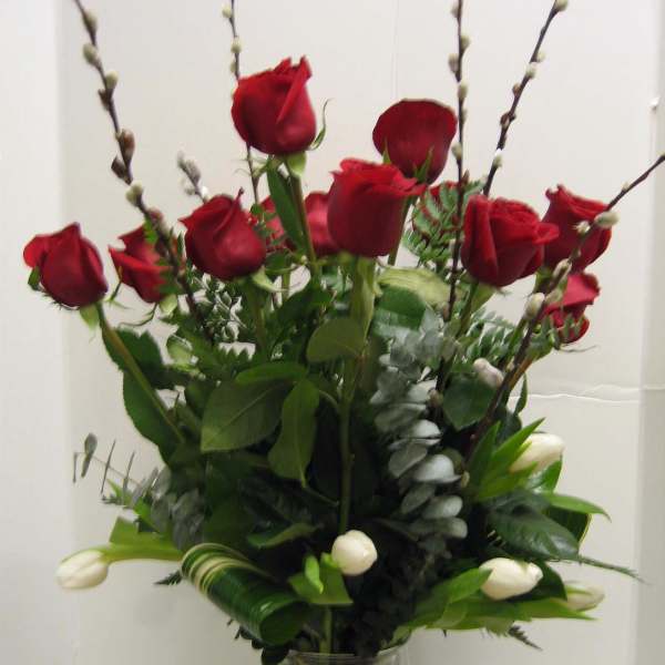 Red roses and white tulips in a clear glass vase