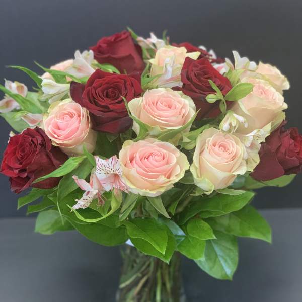 Bouquet of red and blush roses in a glass vase
