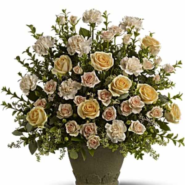 Arrangement of peach and white roses in a brown vase