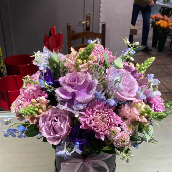 Lavender and pink mixed bouquet in a black hatbox with a ribbon