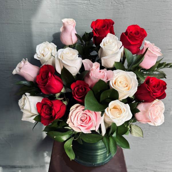 Bouquet of red, white, and pink roses in a green vase