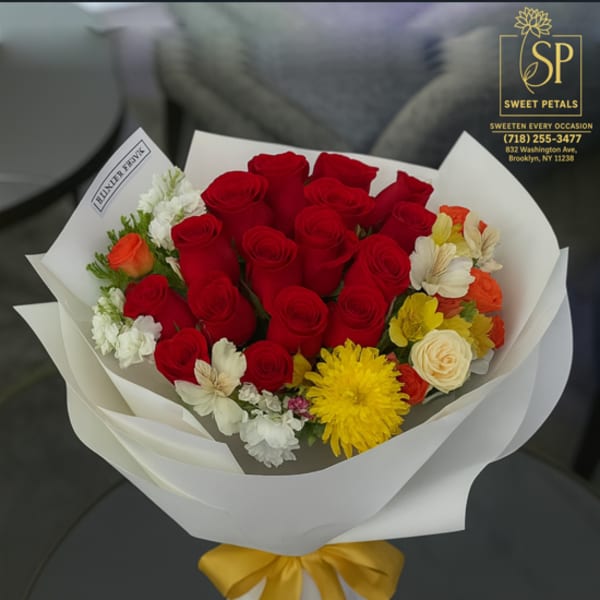 Bouquet of red roses with yellow and white flowers wrapped in white paper