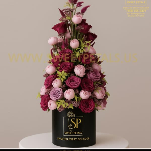 Tall arrangement of pink and burgundy roses in a black box