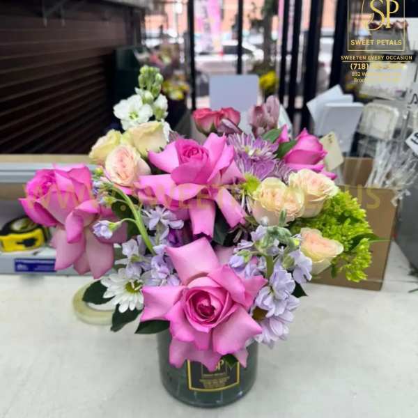 Pink and lavender rose bouquet in a dark vase