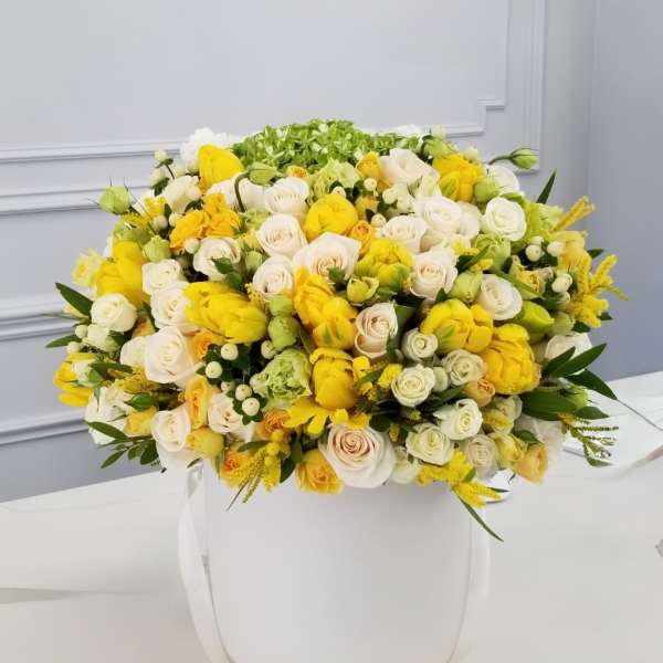 Large bouquet of yellow and white roses in a white hatbox