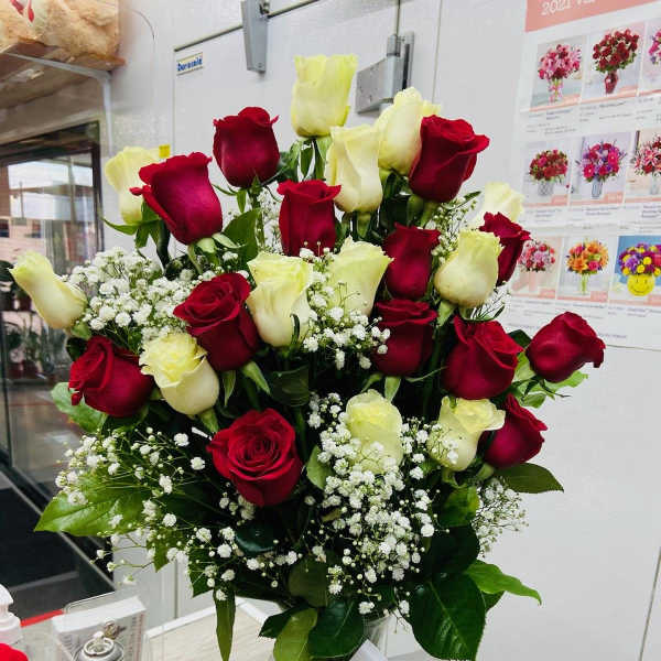 Bouquet of red and white roses in a glass vase with a white ribbon