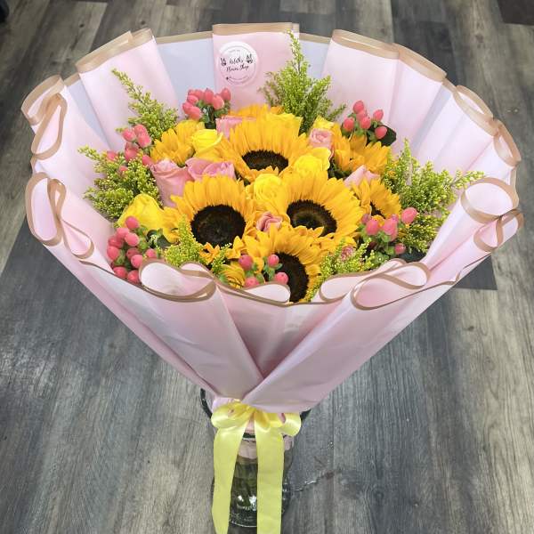 Bouquet of sunflowers and pink roses wrapped in pink paper