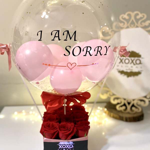 Clear balloon with pink balloons and red roses in a box