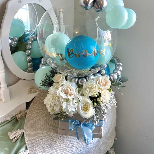 Birthday balloon display with white roses and hydrangeas in a gift box