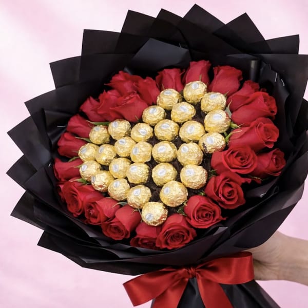 Bouquet of red roses with gold-wrapped chocolates in black paper