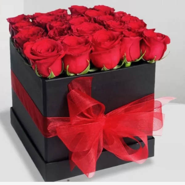 Black gift box filled with red roses and tied with a red ribbon