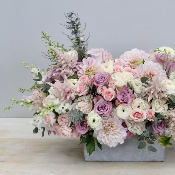 Pastel floral arrangement in a rectangular gray vase