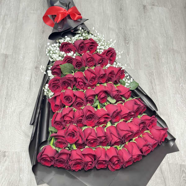Large bouquet of red roses wrapped in black paper with a red bow