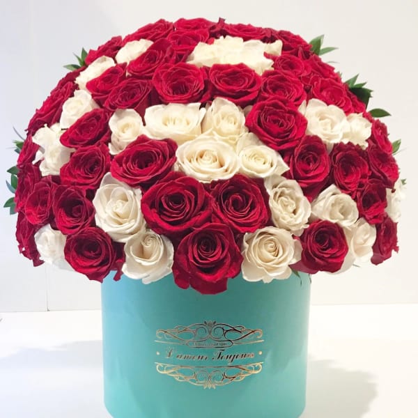 Red and white roses arranged in a turquoise hat box