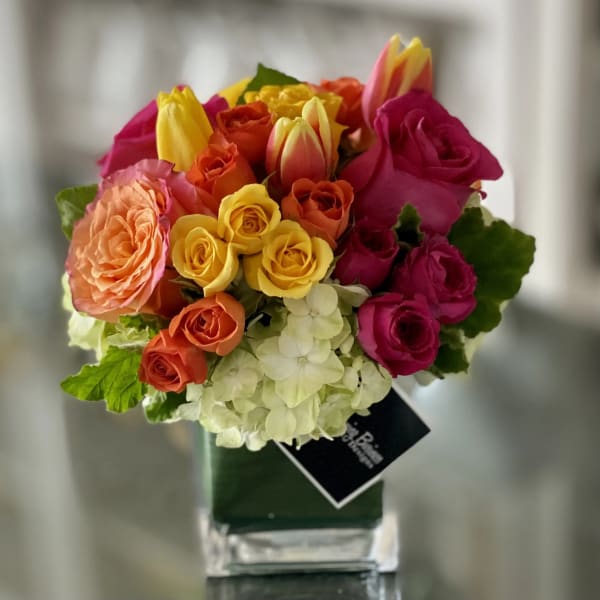 Mixed bouquet of roses and tulips in a square glass vase