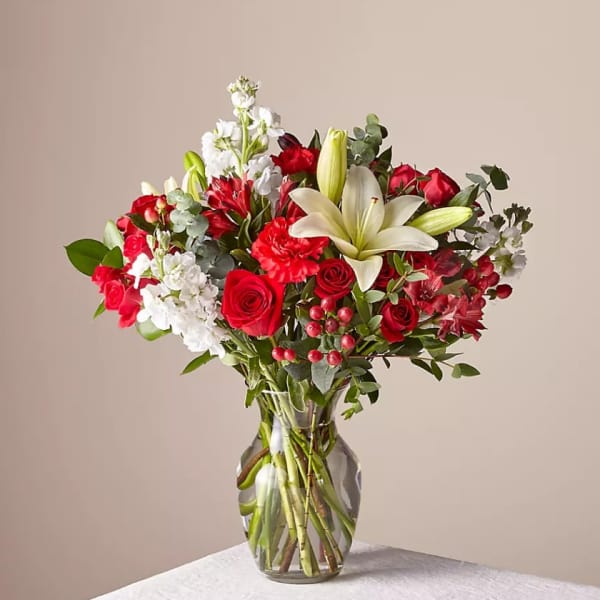 Red and white mixed flower bouquet in a clear glass vase
