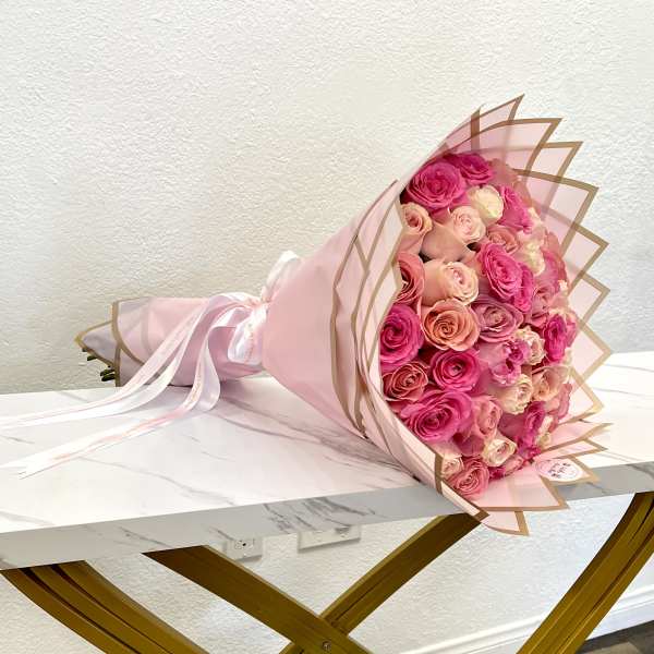 Pink and peach rose bouquet wrapped in pale pink paper